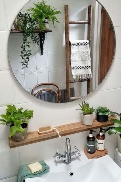 banheiro com plantinhas e espelho refletindo a decoração contemporânea 