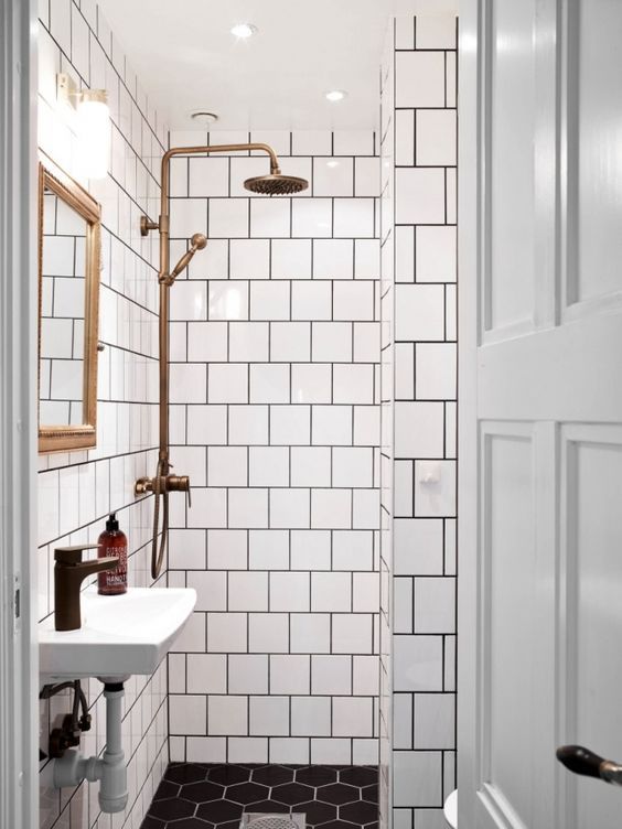 Banheiro Branco Vintage Com azulejos Brancos com detalhes Pretos e decorações em tons de Cobre
