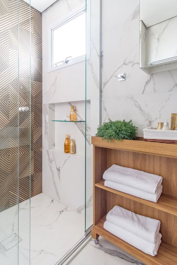 Banheiro marmorizado com detalhes de madeira
